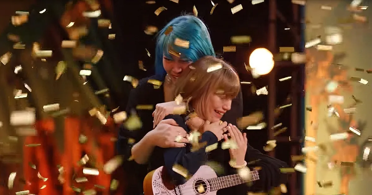 Two people are embracing amidst falling confetti, one holding a ukulele.
