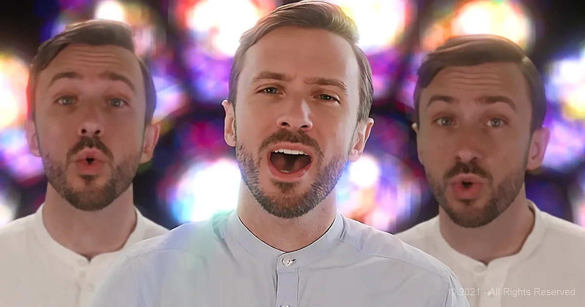 A man in a light blue shirt sings with two others in a colorful, vibrant background.