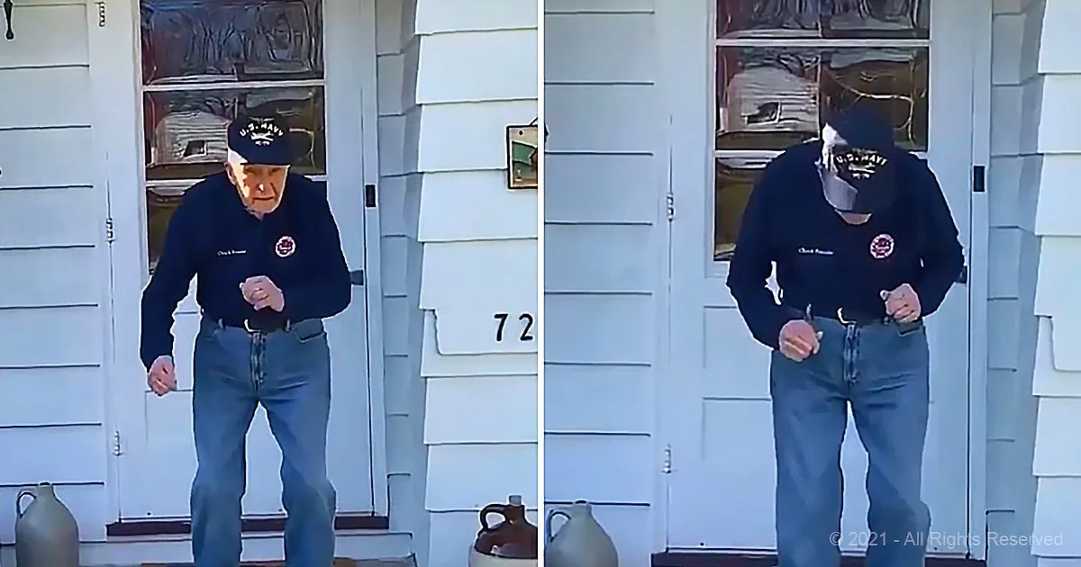 An older man in a navy uniform and cap stands on a porch, holding something in his hands.