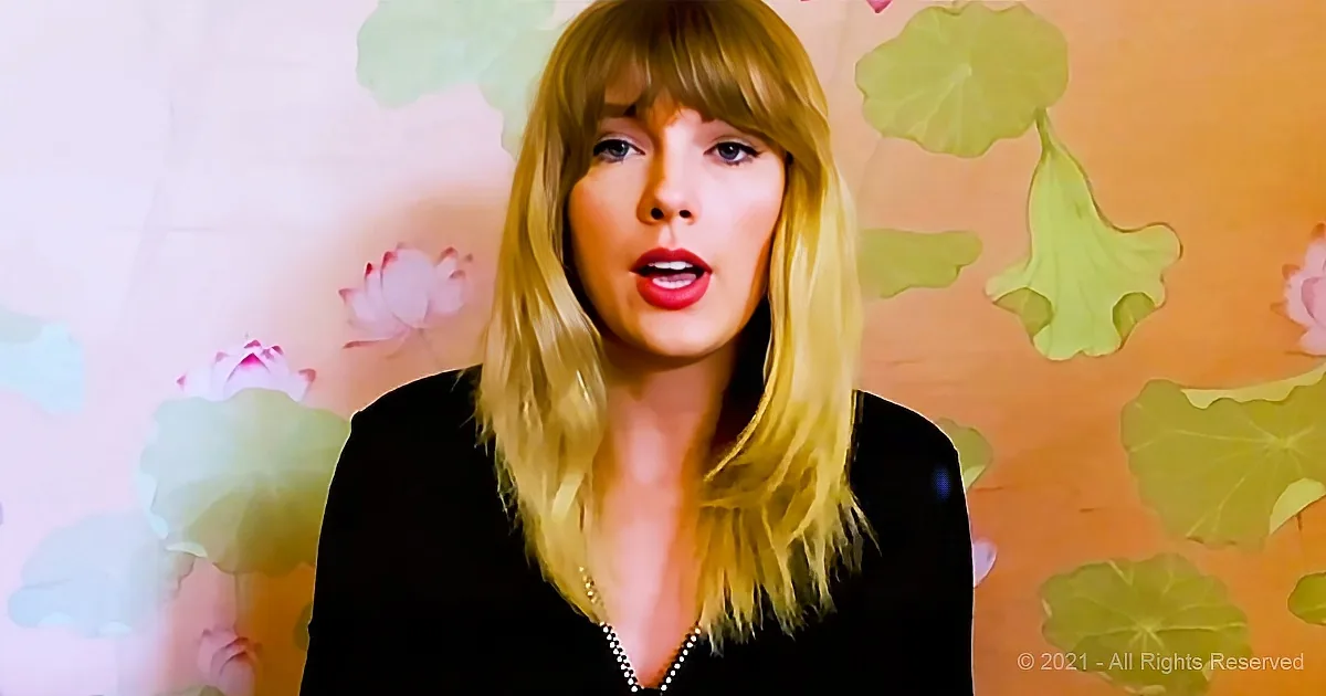 A person with blonde hair and red lipstick stands in front of a background with pink flowers and green leaves.