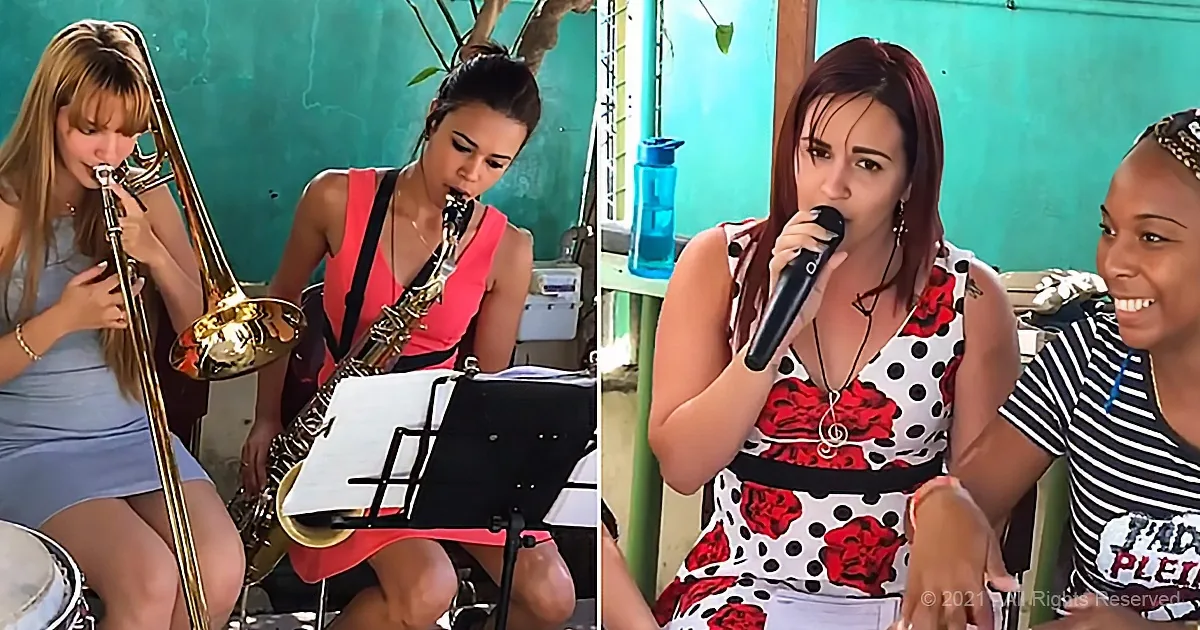 A woman in a red dress plays the saxophone while another sings into a microphone.