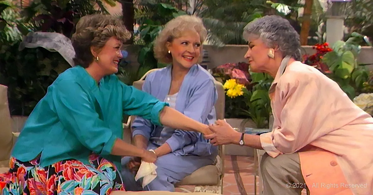 Three women in a garden setting, one in teal and floral skirt shaking hands with another in pink, while the third in blue...
