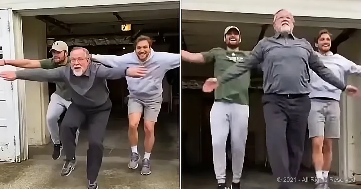 Three men in casual attire are dancing and having fun in a garage.