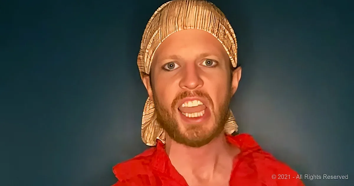 A person wearing a straw hat and red outfit is shown against a dark background.