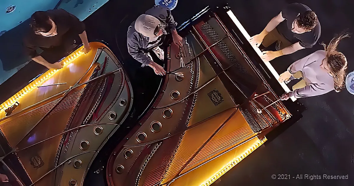 A group of people is examining and working on a large, ornate piano with its lid open.