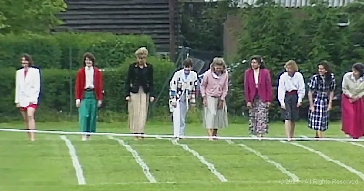 A group of women in various outfits stands on a grassy field, some in formal wear, others in casual attire.