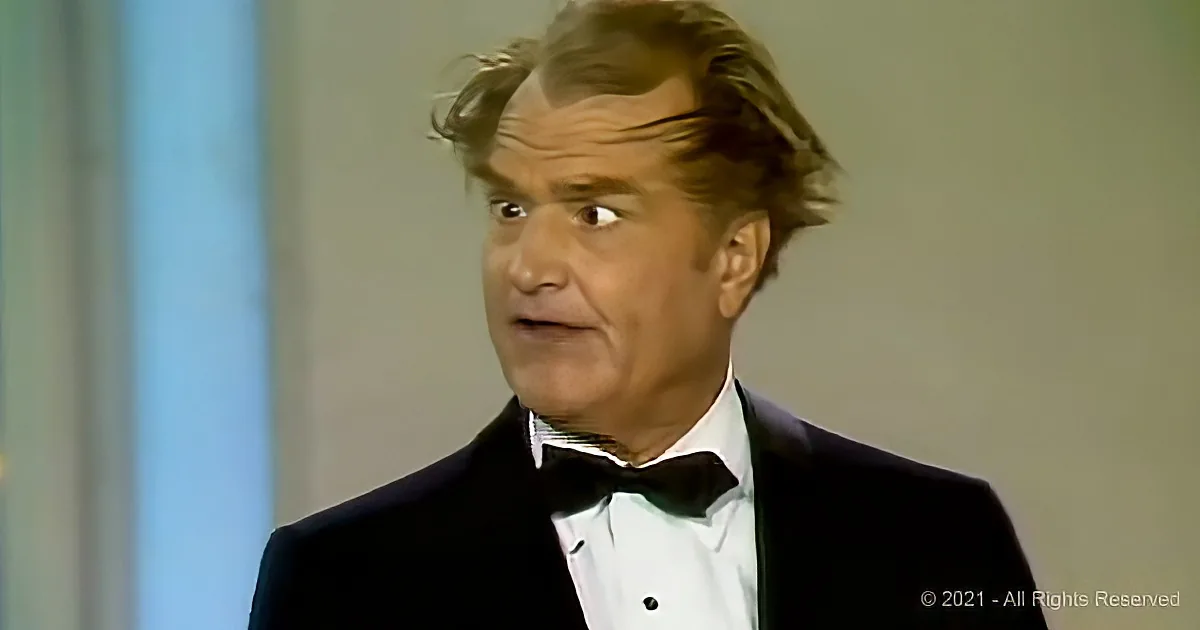 A man in a tuxedo with a bow tie and white shirt appears surprised or shocked.