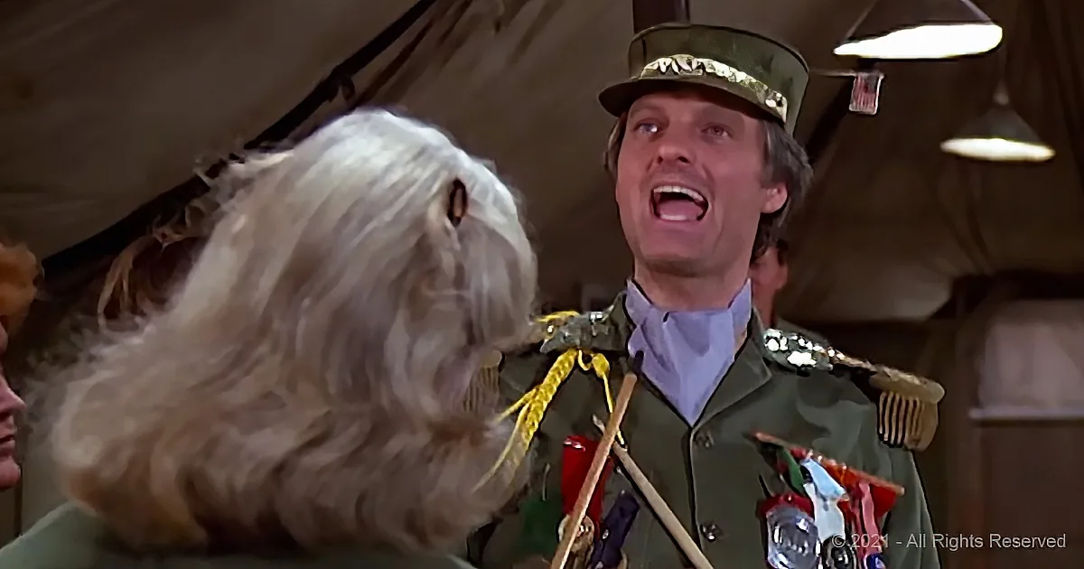 A man in a military uniform is yelling at a fluffy white dog in a tent.