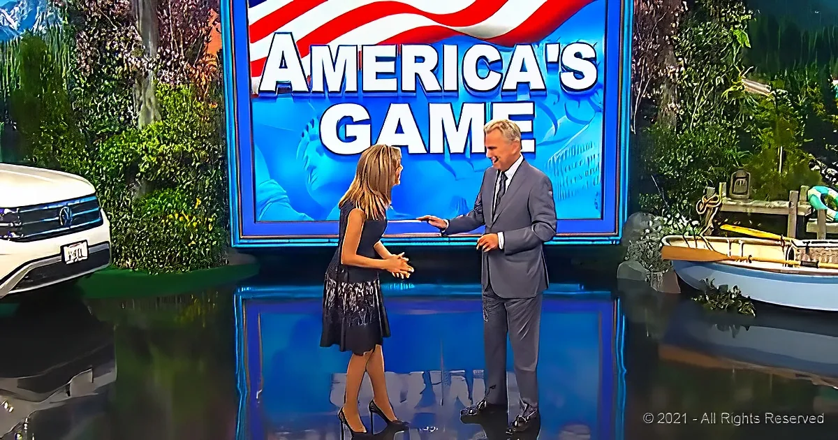 A man in a suit and a woman in a dress stand in front of a "America's Game" sign with a car and a boat nearby.