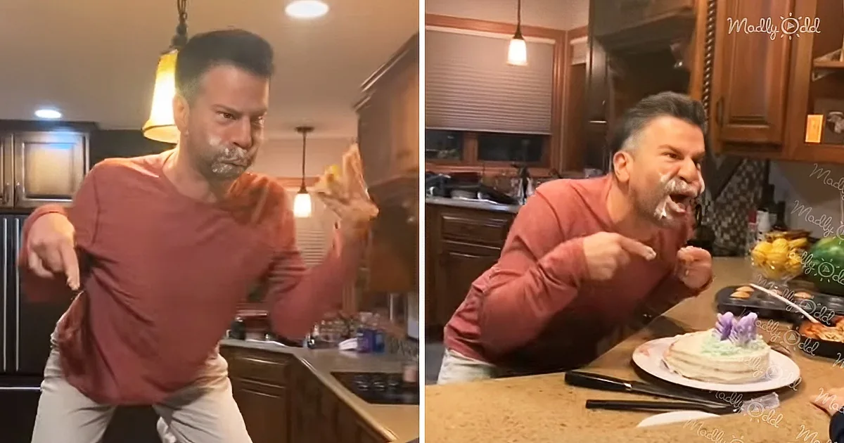 A man in a red shirt dances and celebrates in a kitchen, surrounded by a cake and kitchen items.
