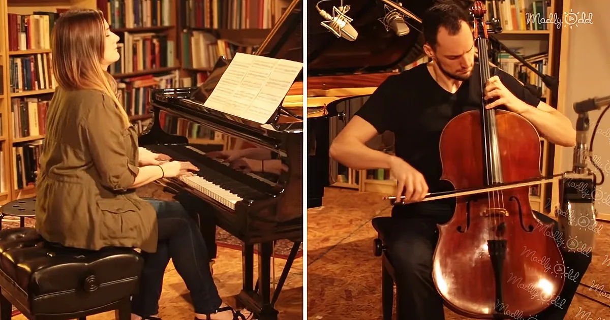 A woman plays piano while a man plays cello in a cozy room with bookshelves.