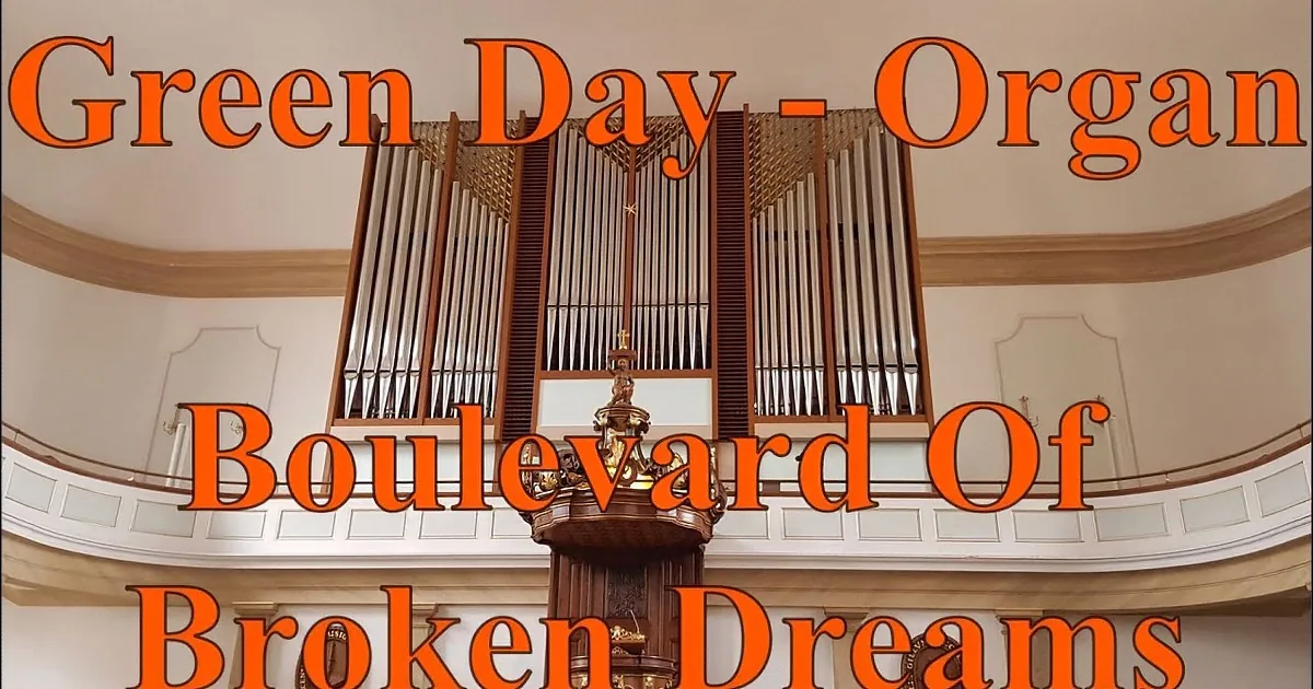 A person in a striped shirt plays an organ, focusing on the keys and sheet music.