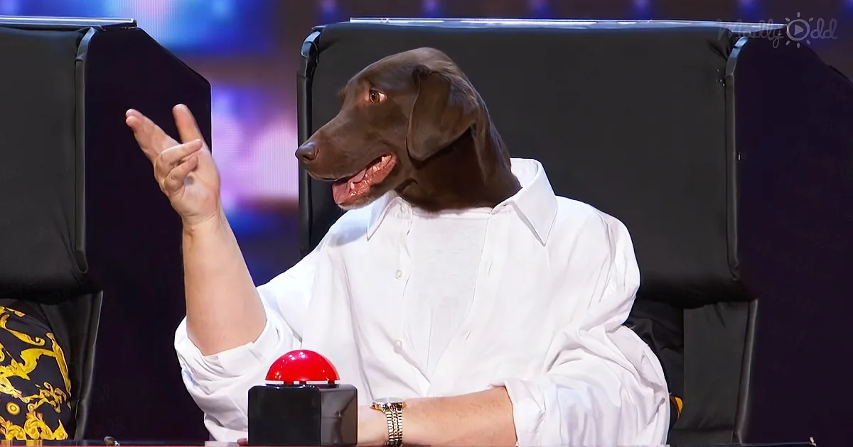 A person in a white shirt with a dog's head is sitting at a desk, making a peace sign with their hand.