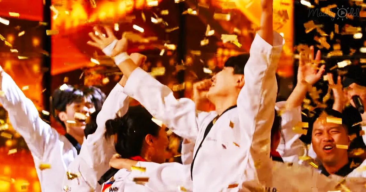 A group of people in white uniforms celebrate with raised arms amidst falling confetti, creating a festive atmosphere.