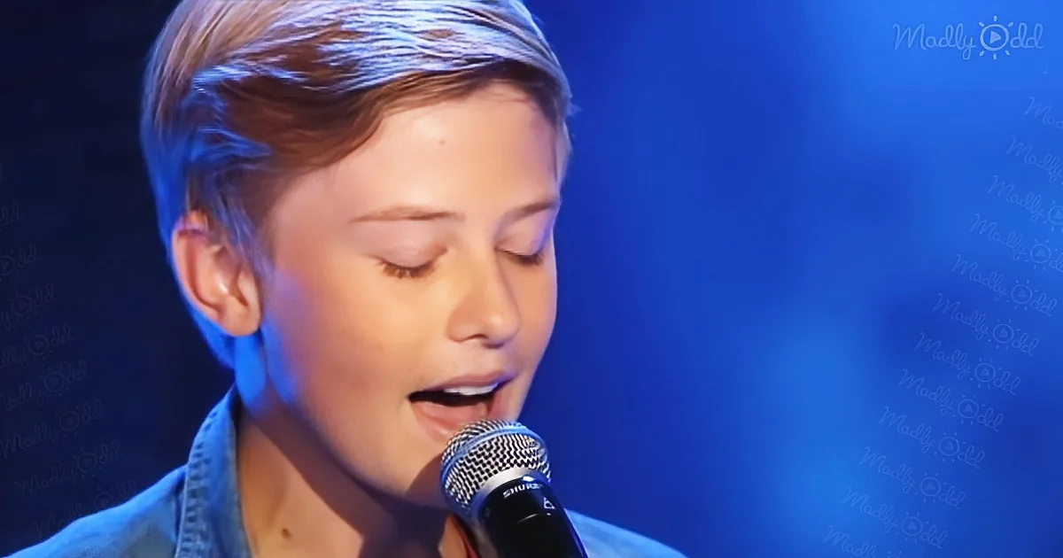 A person singing into a microphone with a blue background and "Madly Odd" text.