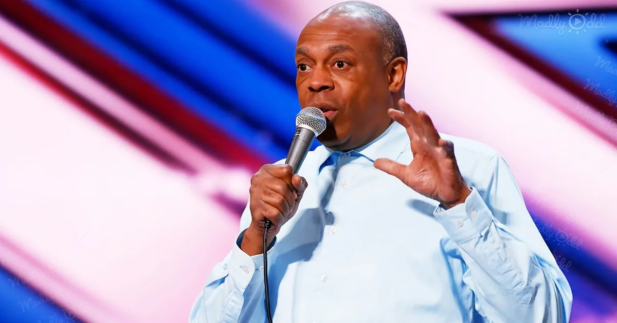 A man in a light blue shirt holds a microphone, gesturing with his other hand, against a colorful background.