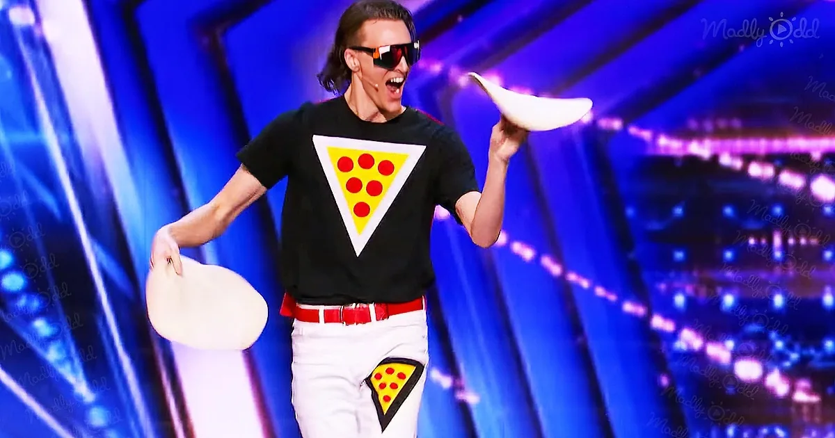 A person in a pizza-themed outfit is juggling pizza slices on a stage with a vibrant blue background.