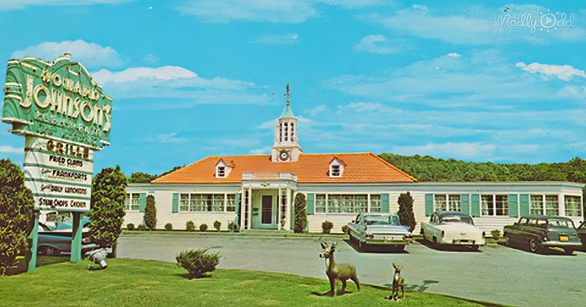 Howard Johnson's roadside diner with vintage cars and sign, green and white building, blue sky.