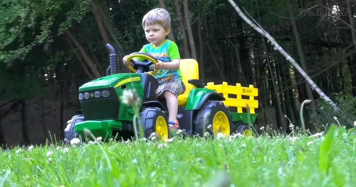 Adorable Little boy riding John Deere tractors