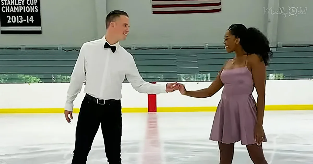 A man and woman in formal attire hold hands on an ice rink, smiling at each other.