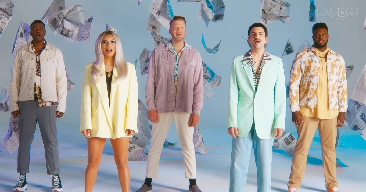 Five people in pastel outfits stand against a blue background with newspapers flying around them.