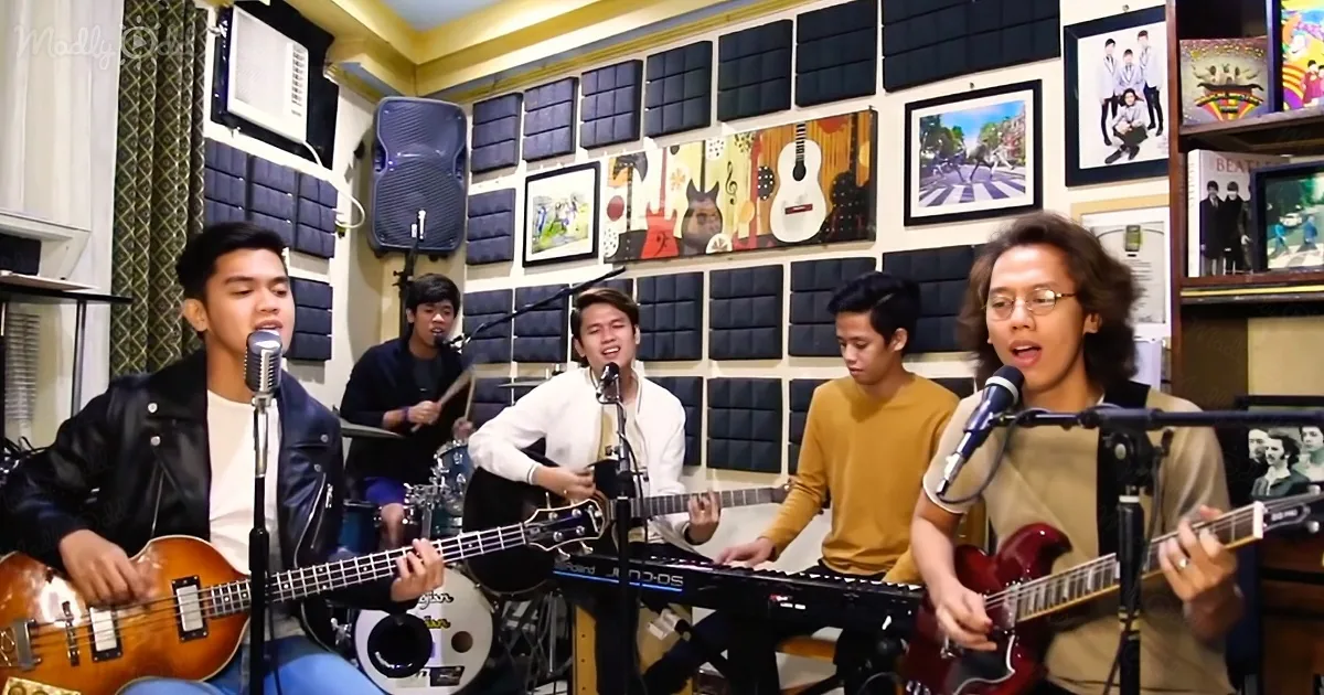 A band performs in a cozy studio with microphones, guitars, and a keyboard.