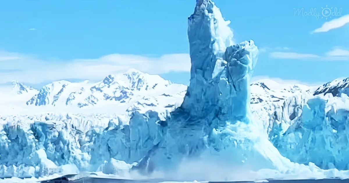 A towering ice formation rises dramatically from a glacier landscape under a bright blue sky.
