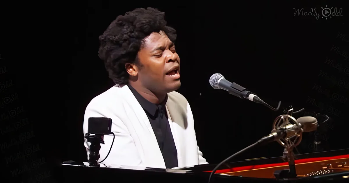 A person in a white jacket sings into a microphone while playing a piano.