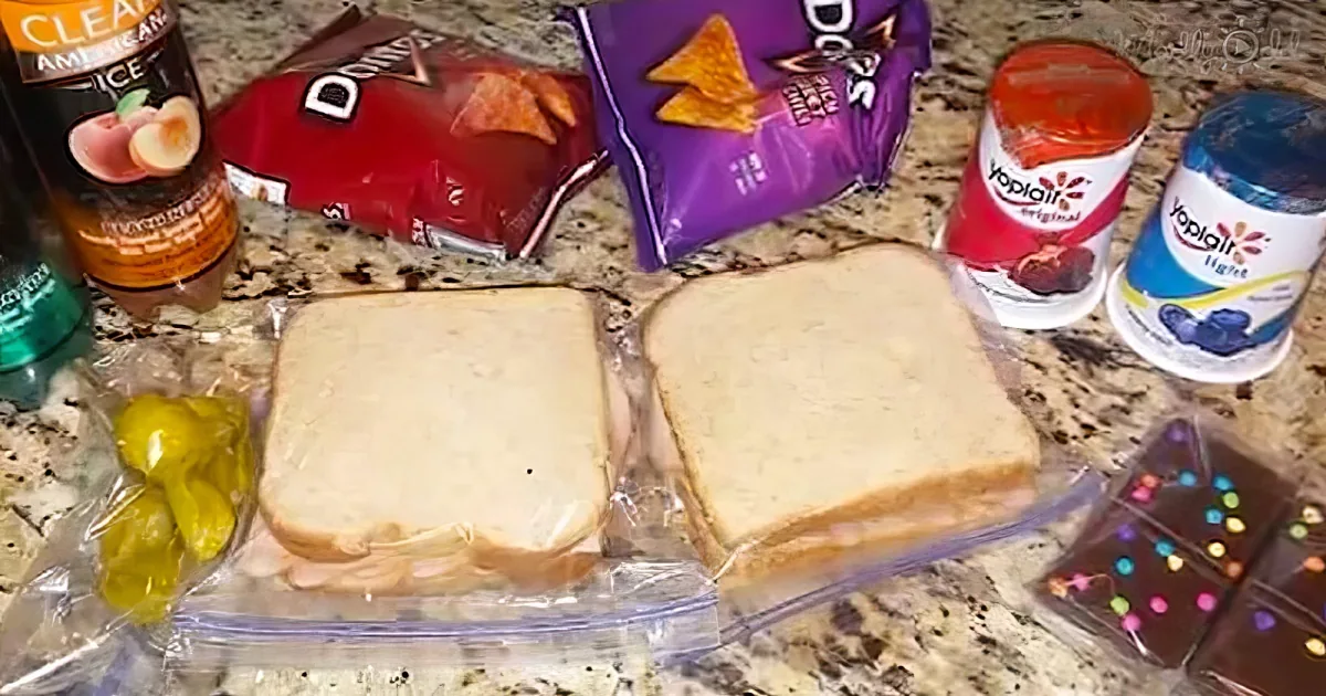 Two slices of white bread are on a countertop with various snacks and drinks around them.