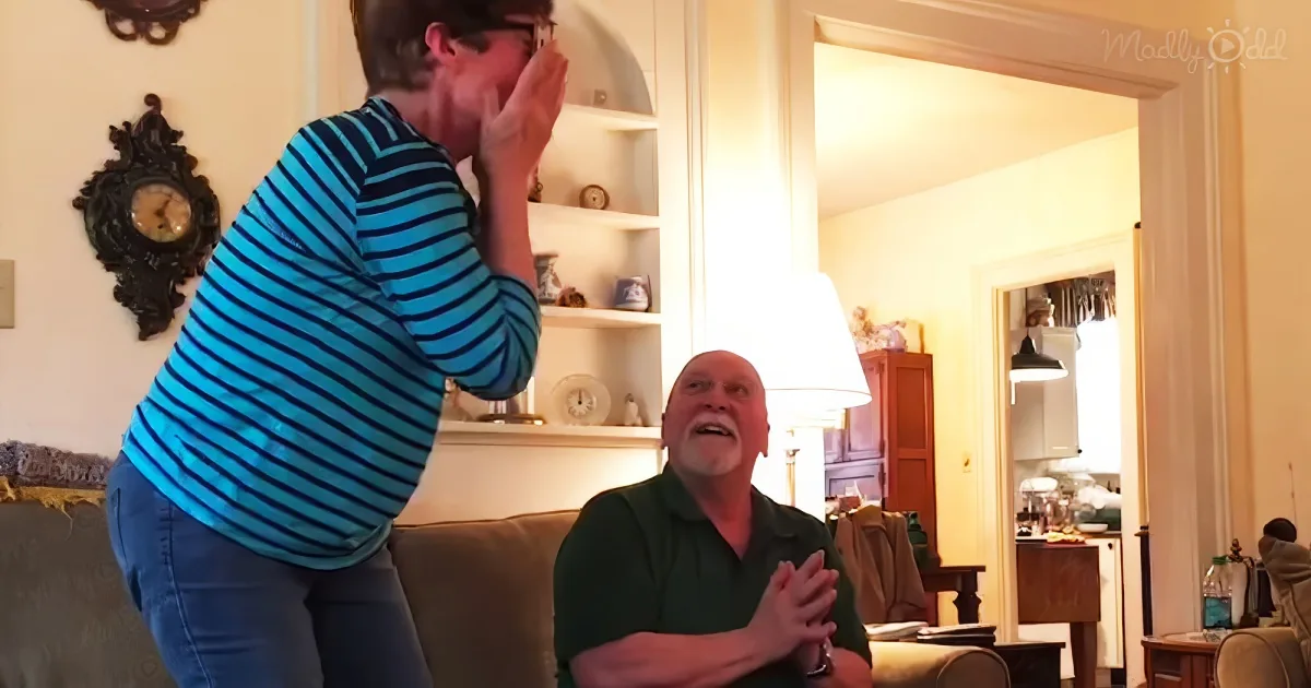 A person in a striped shirt is playfully interacting with another person in a green shirt in a cozy living room setting.