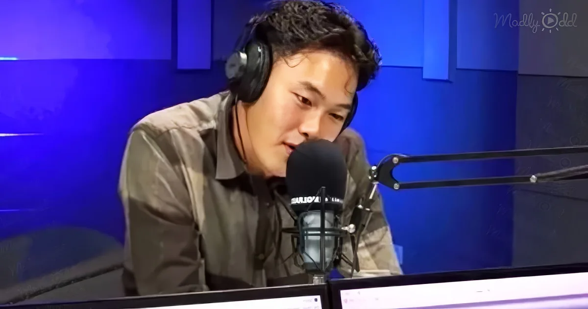 A man wearing headphones speaks into a microphone in a radio studio setting.