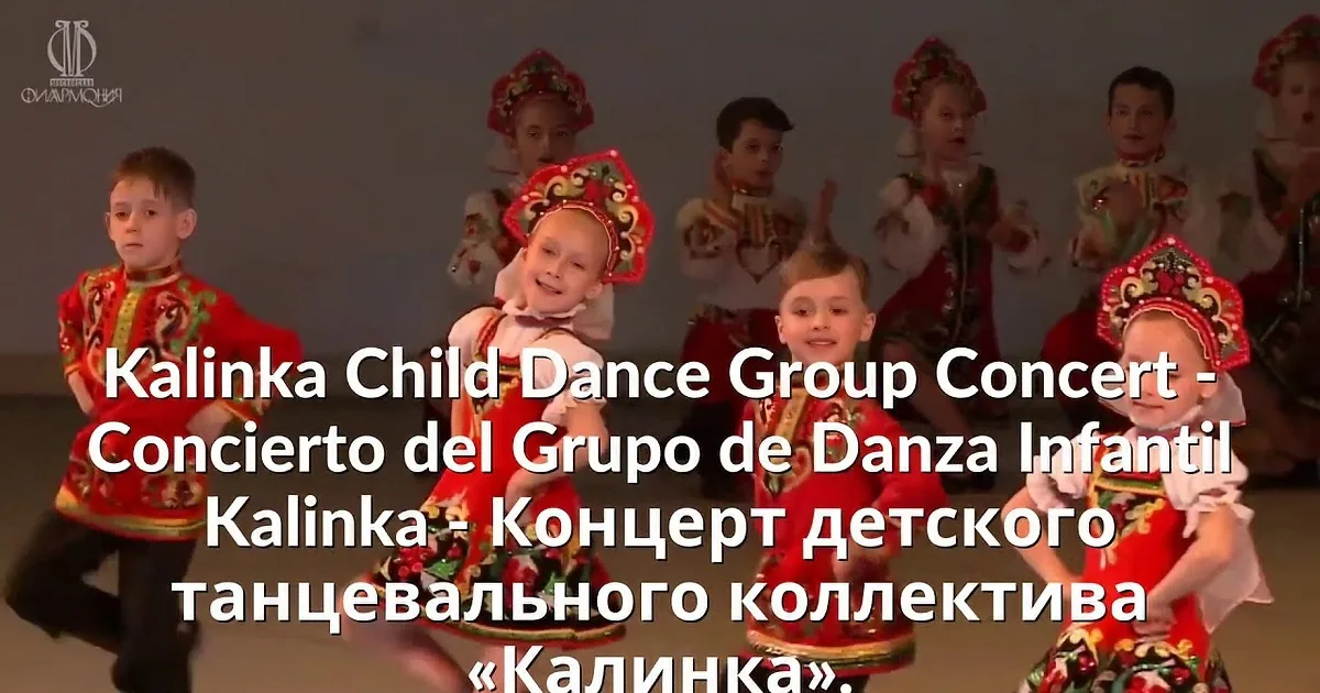 A group of performers in traditional attire raises their arms in unison on stage.