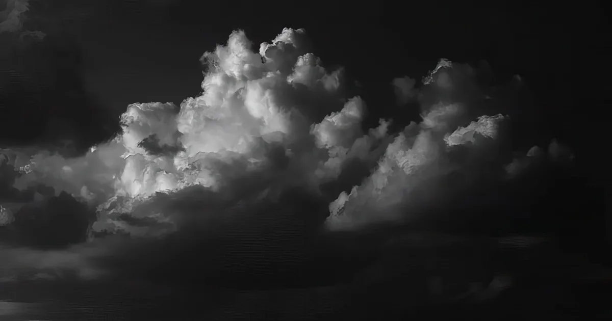 A dramatic black-and-white cloud formation with a bright, textured center against a dark background.