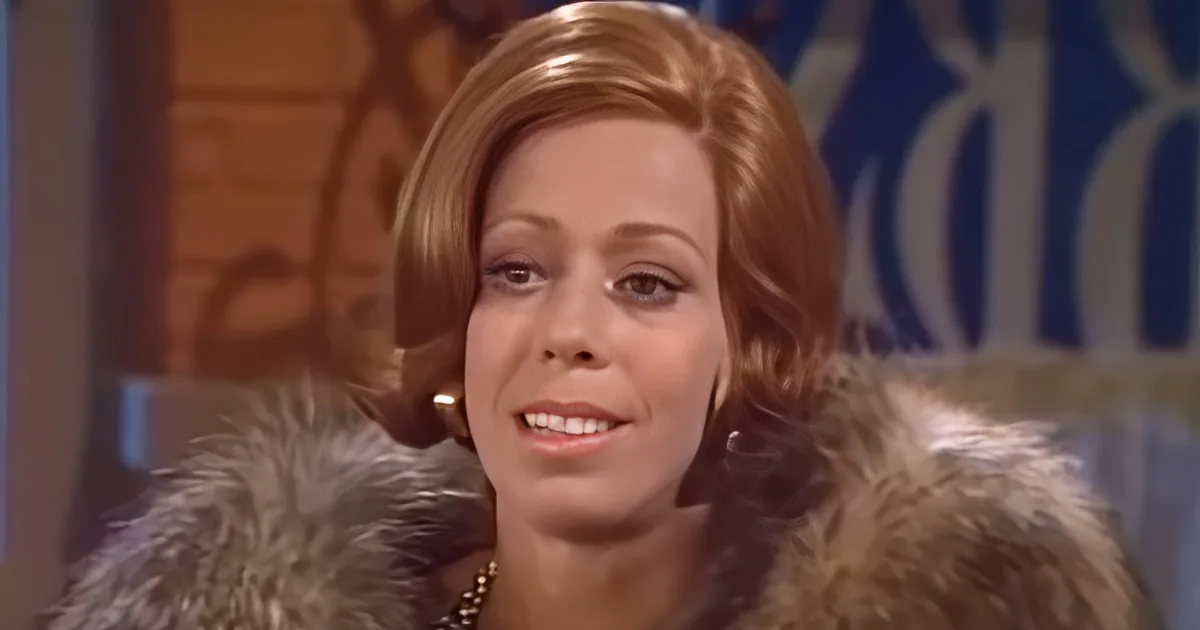 A woman with red hair and a fur coat is shown in two close-up frames, possibly from a TV show or interview.
