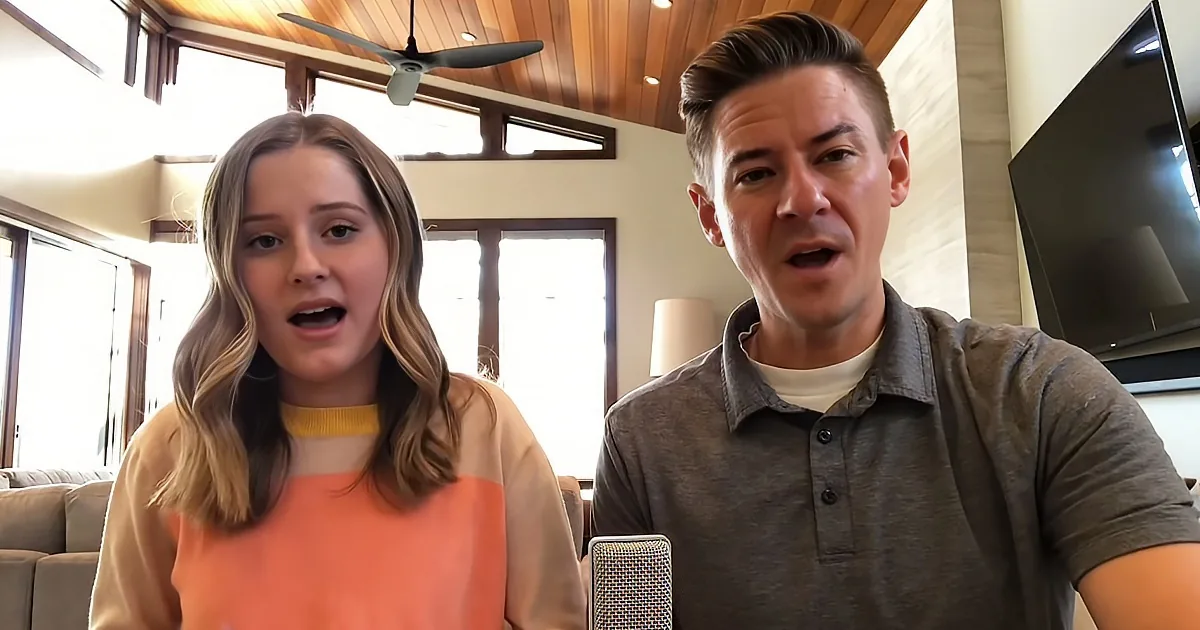 A man and a woman are standing indoors, both looking surprised or shocked.