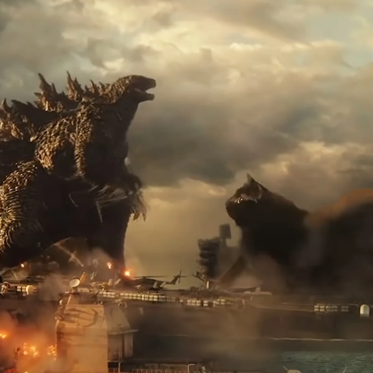 Two giant monsters, Godzilla and King Ghidorah, clash in a fiery, apocalyptic cityscape.
