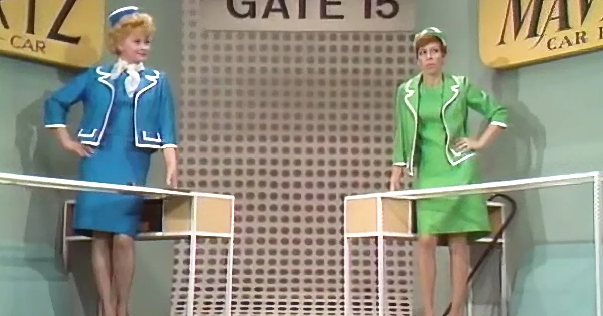 Two women in flight attendant uniforms stand on platforms, one in blue, the other in green, with "Gate 15" sign in the...