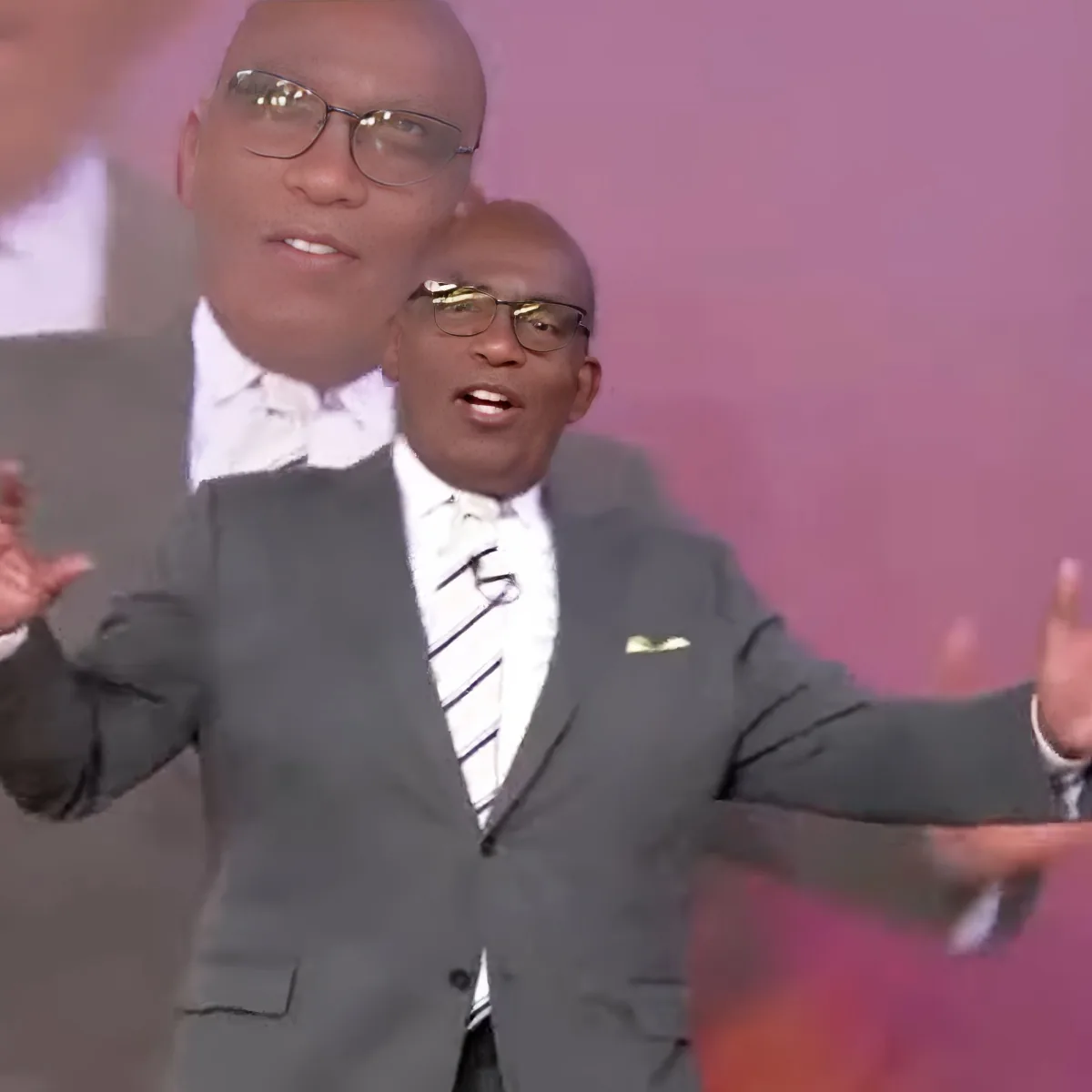 A man in a suit and tie gestures with his hands while speaking.