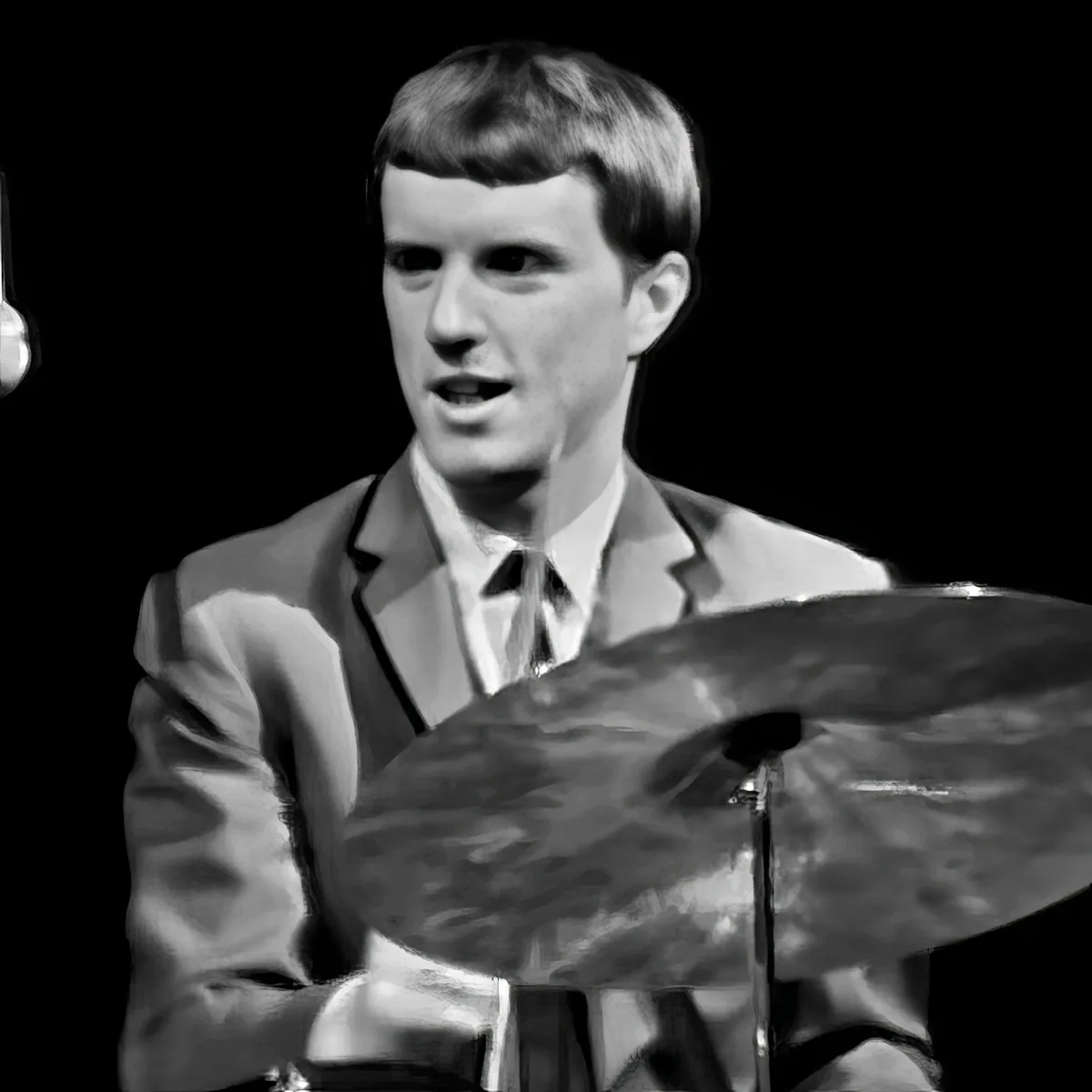 A man in a suit and tie is playing drums, captured in a black-and-white image.
