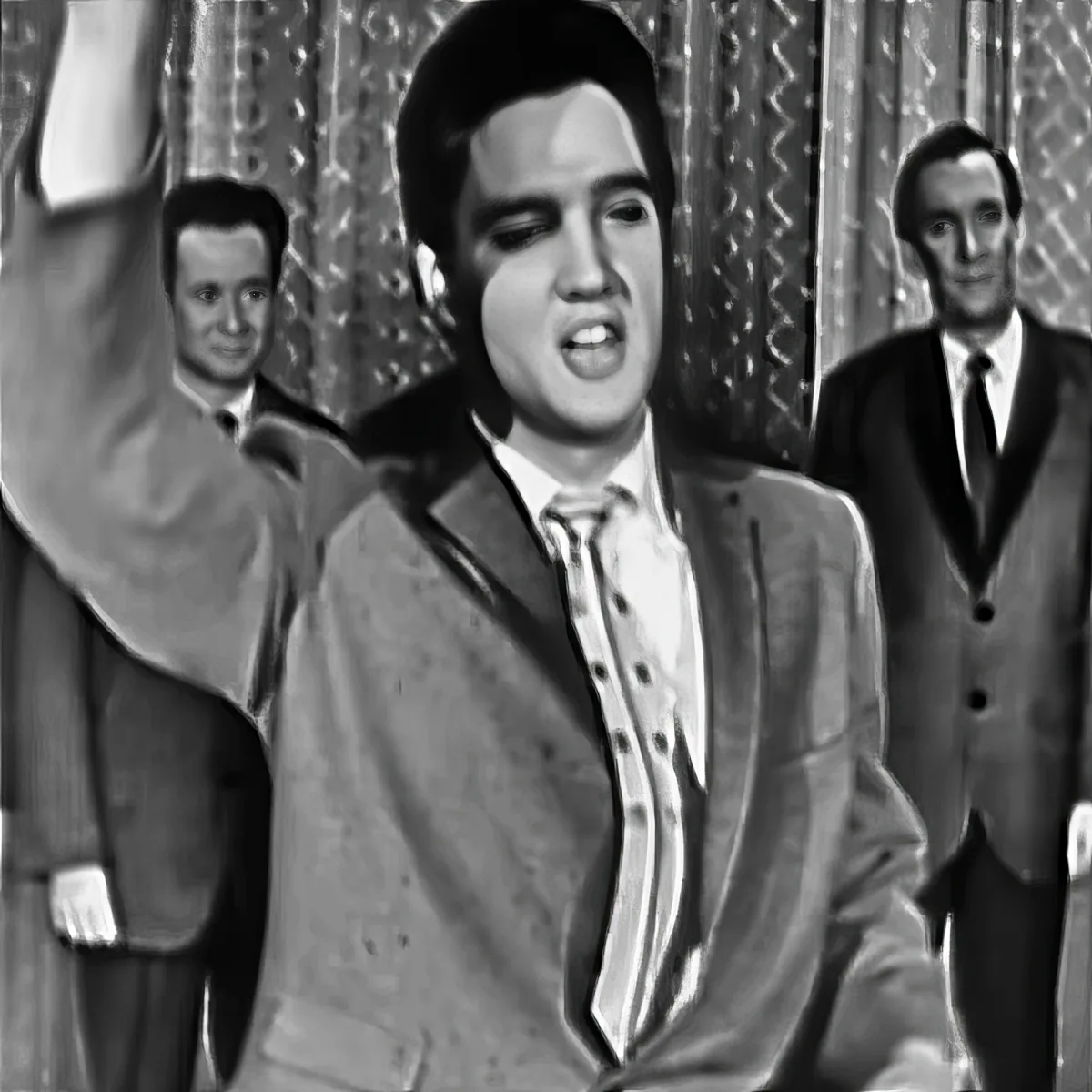 Elvis Presley in a suit and tie, singing with two backup singers behind him.
