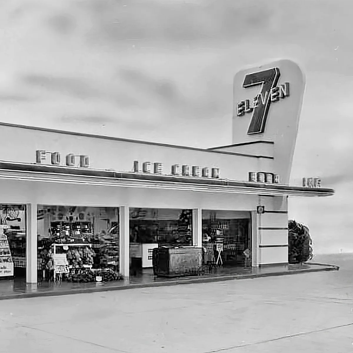 A vintage 7-Eleven store with a prominent sign, food and ice cream signage, and a view of the interior.