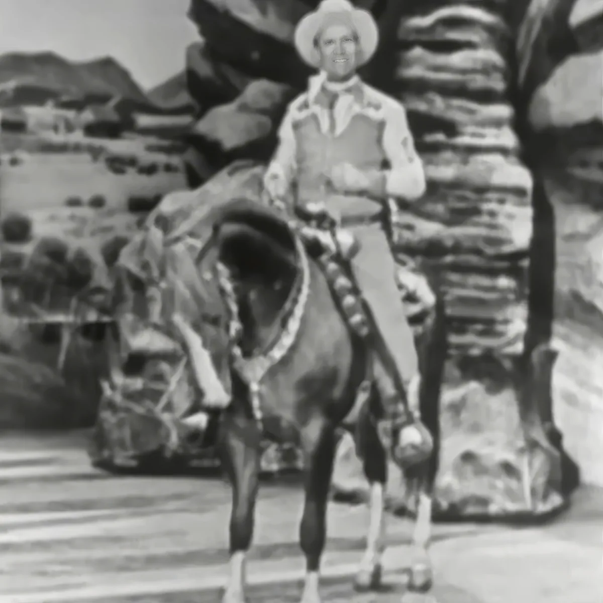 A cowboy in a white shirt and hat stands on a horse, surrounded by rocky terrain.