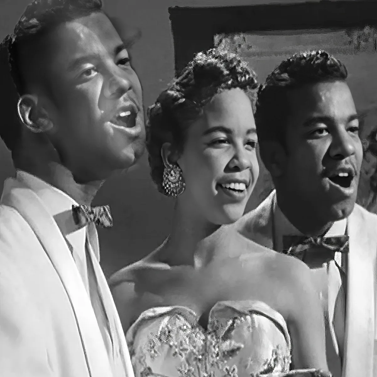 A woman in a dress sings with two men in suits, all smiling and looking upwards.