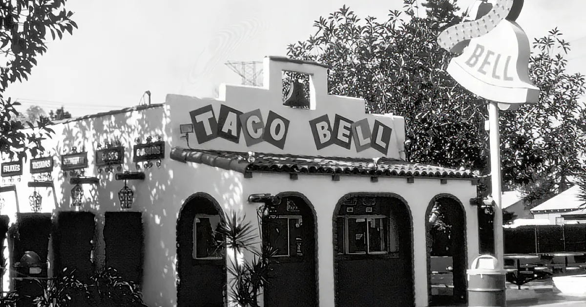 A Taco Bell restaurant with a distinctive bell-shaped sign and Spanish-style architecture.