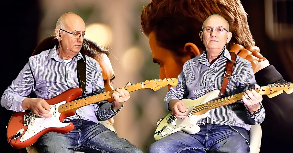 A man in a striped shirt plays a red electric guitar, with another person partially visible behind him.