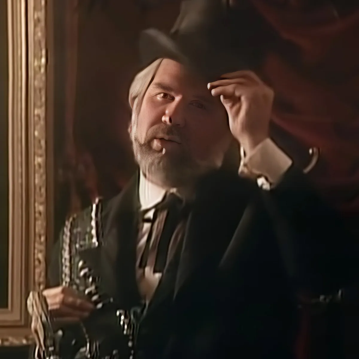 A man in formal attire adjusts his hat while holding a saxophone, standing in a dimly lit room.