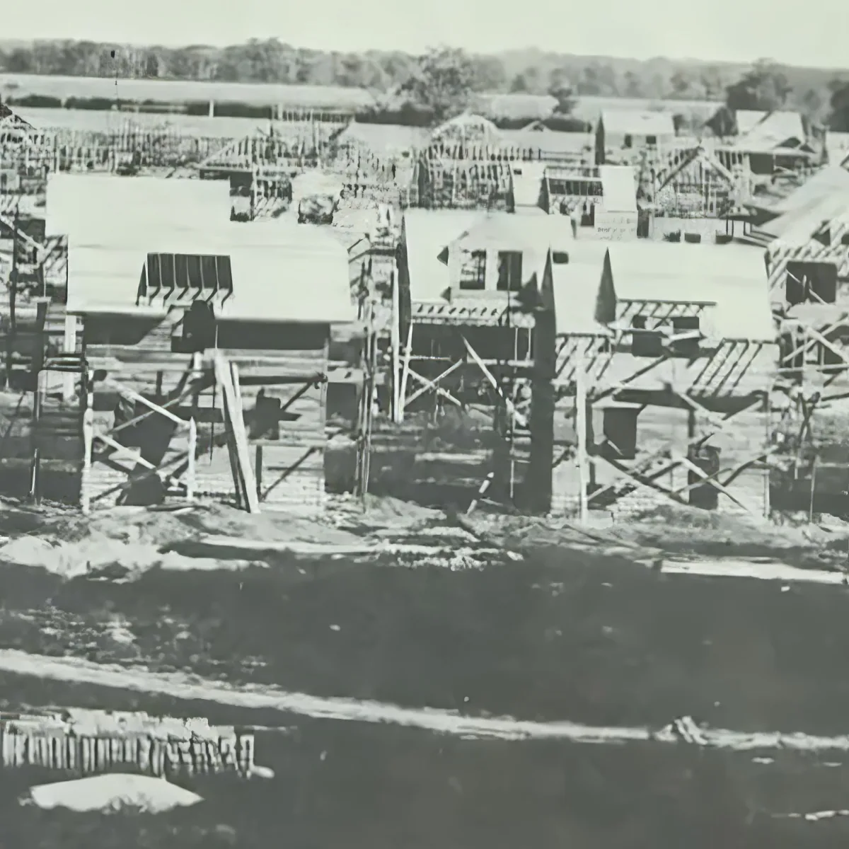 A construction site with partially built wooden structures and scaffolding.
