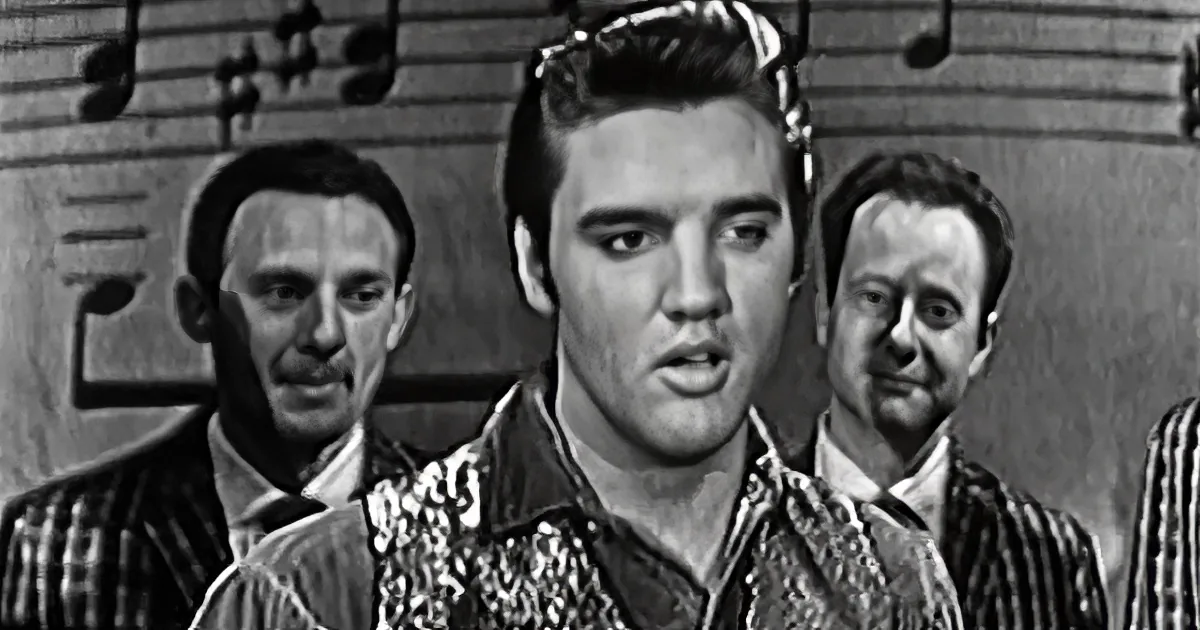 Elvis Presley in a black-and-white scene, wearing a sequined jacket, with two men behind him.