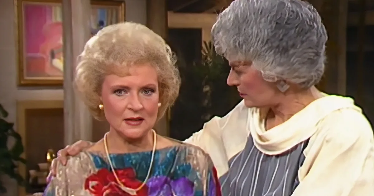 Two women, one with blonde hair and a blue dress, the other with gray hair and a white top, are interacting in a room...