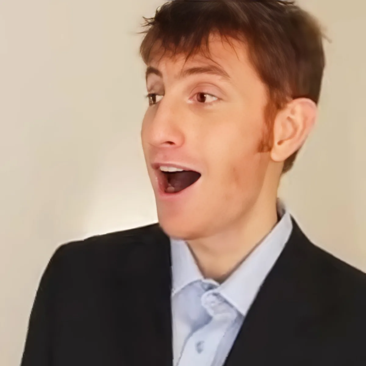 A person in a suit and tie is making a surprised or shocked expression.